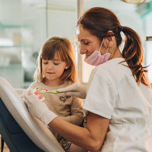 dentist showing child how to brush