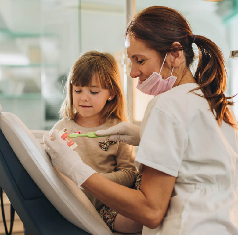 dentist showing child how to brush