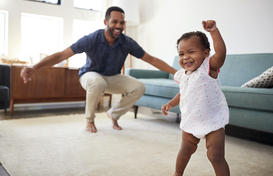 Black dad dances in the family room with his toddler daughter before her first dental appointment in Austin, TX