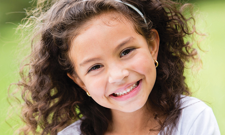 little girl with curly hair smiling