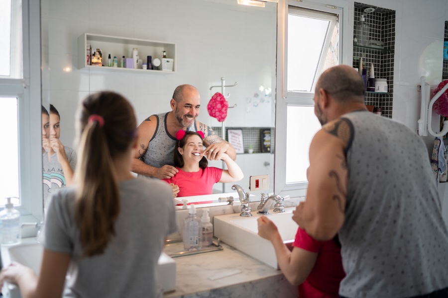 special needs pediatric dentistry, father helping daughter brush her teeth